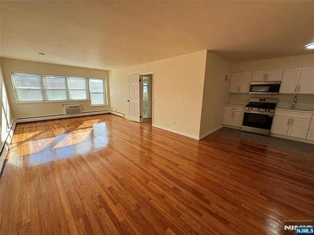 a view of a kitchen with wooden floor and electronic appliances
