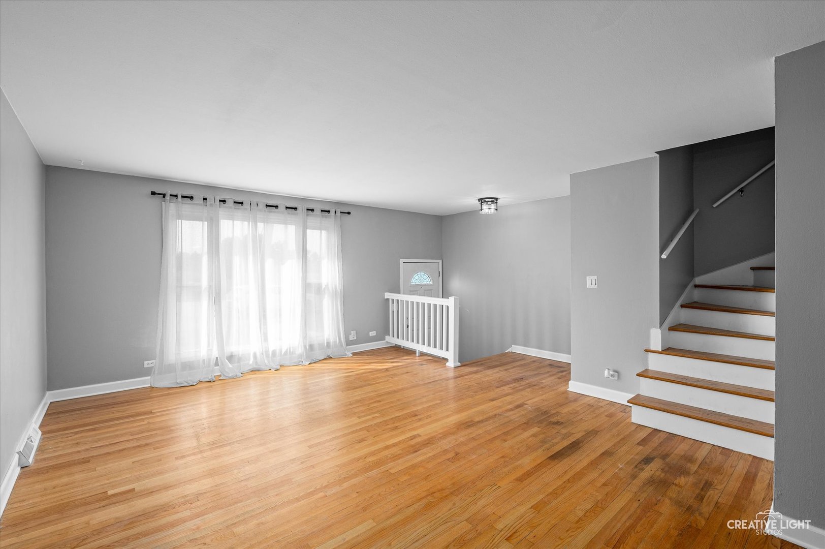 8802 Prospect Street Niles, IL 60714 - Photo 4 of 20 a view of an empty room with wooden floor and a window