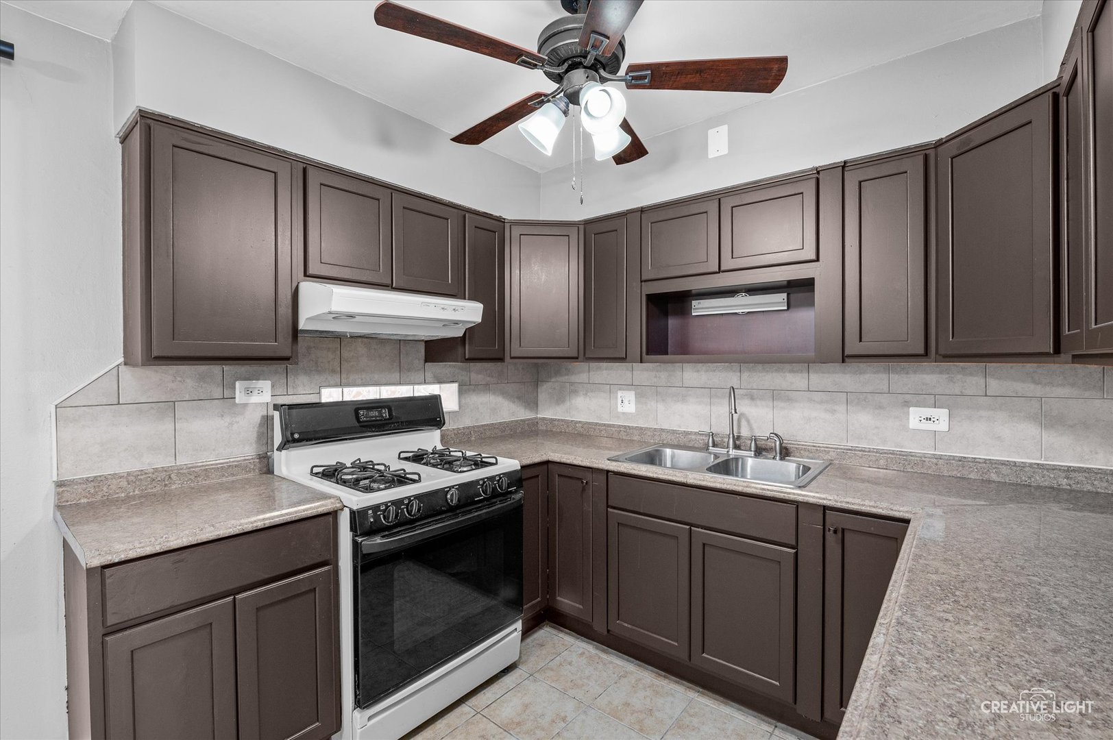 8802 Prospect Street Niles, IL 60714 - Photo 7 of 20 a kitchen with stainless steel appliances granite countertop a sink stove a microwave and cabinets