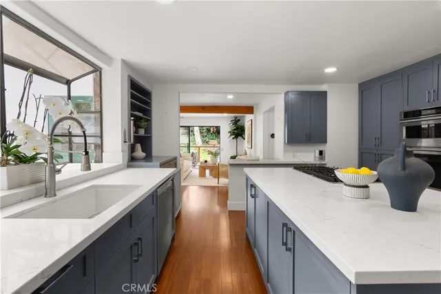 a kitchen with a sink a counter top space and stainless steel appliances