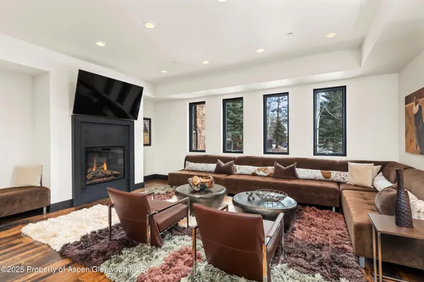 a living room with furniture fireplace and large windows