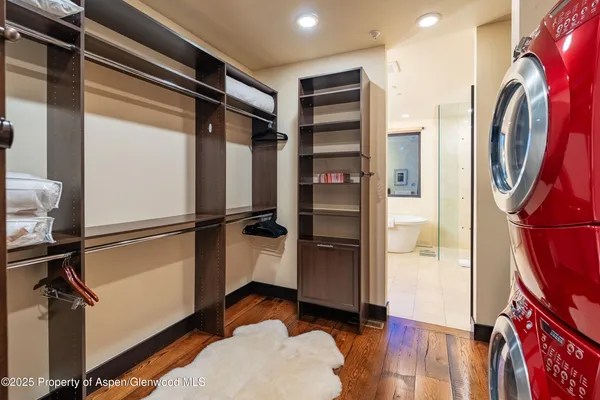 a view of walk in closet with clothes and shoes