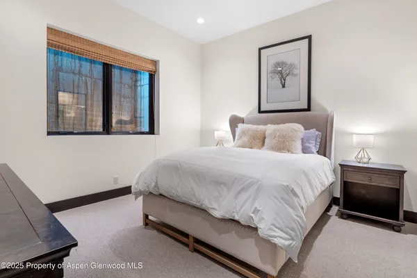 a bedroom with a bed and painting on the wall