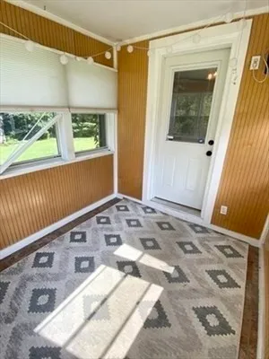 a view of a bedroom with wooden floor and windows
