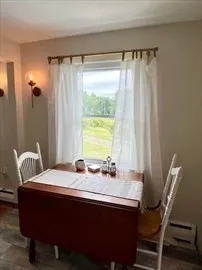 a dining room with a table chairs and a window