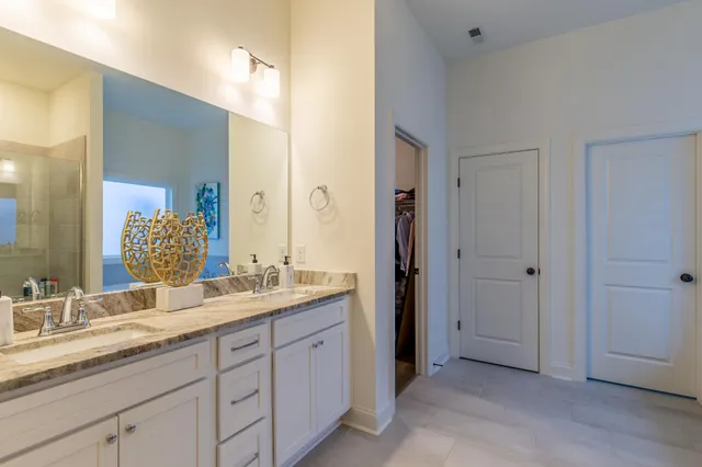 a spacious bathroom with a granite countertop double vanity sink mirror and