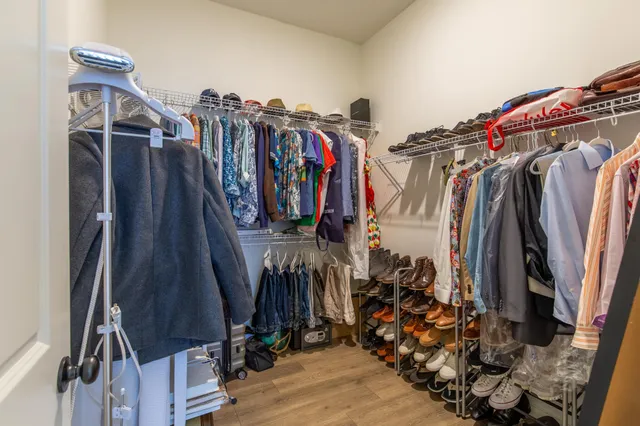 a view of walk in closet with clothes