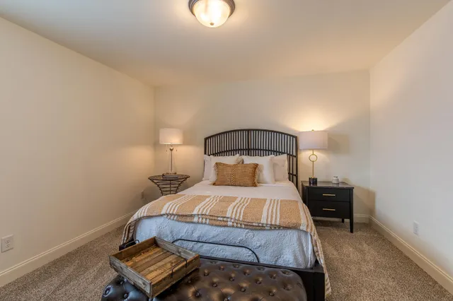 a bedroom with a bed lamp and a dresser