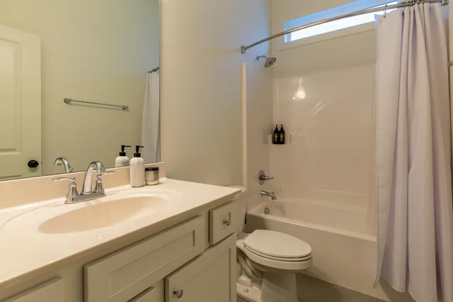 a bathroom with a sink toilet mirror and shower