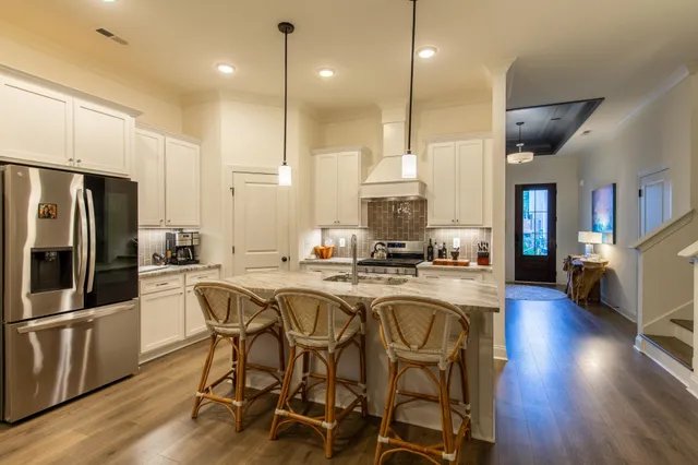 a kitchen with stainless steel appliances granite countertop a table chairs stove and refrigerator