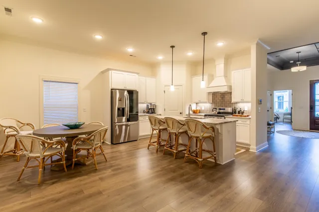 a kitchen with kitchen island granite countertop lots of white cabinets and stainless steel appliances