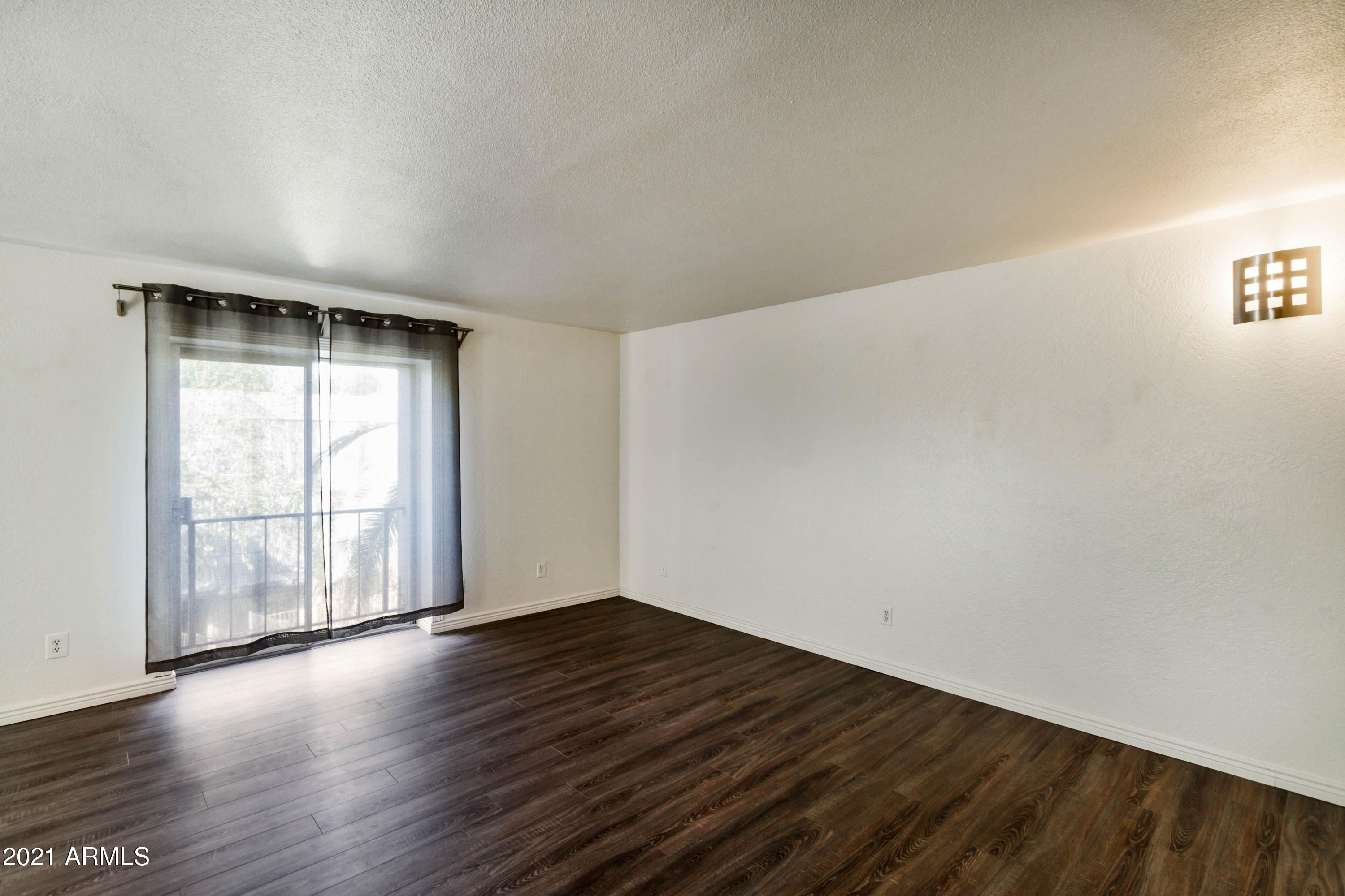1002 East Osborn Road, Unit C Phoenix, AZ 85014 - Photo 7 of 15 an empty room with wooden floor and windows