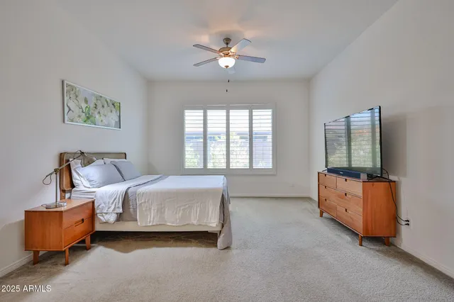 a spacious bedroom with a bed and a chandelier