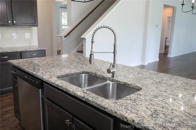 a close view of a sink a counter space and a stove in the kitchen