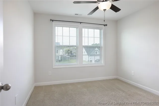 an empty room with a window and a fan