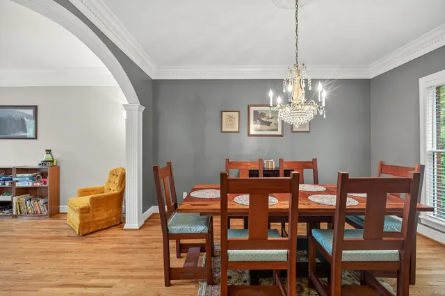 a view of a dining room with furniture wooden floor and chandelier