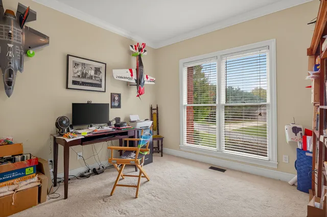 a view of a workspace with furniture and a window