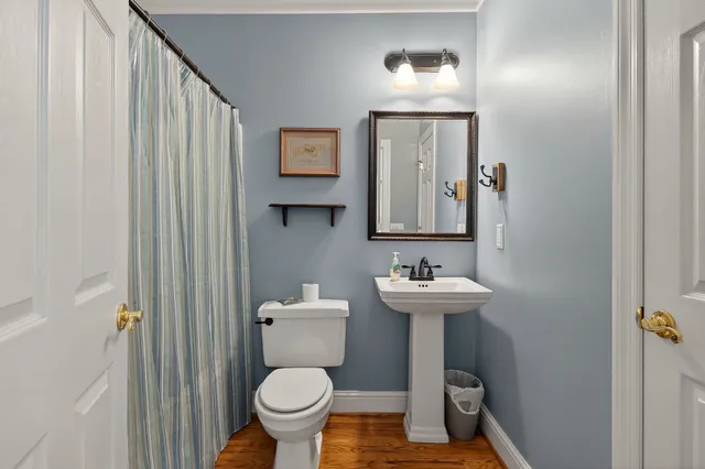 a bathroom with a toilet a sink and mirror