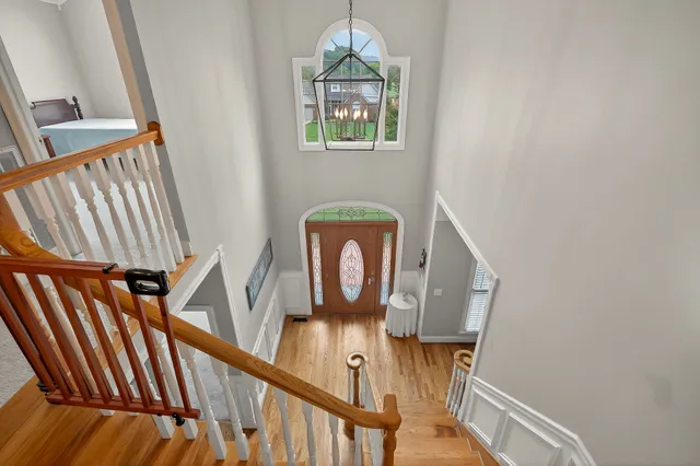 a view of a hallway with wooden floor and staircase