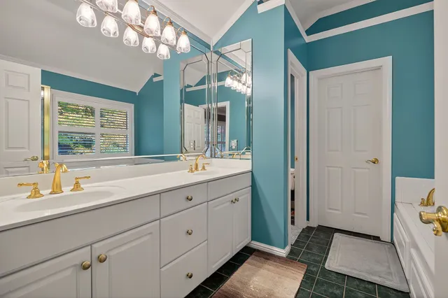 a spacious bathroom with a double vanity sink a mirror and a shower