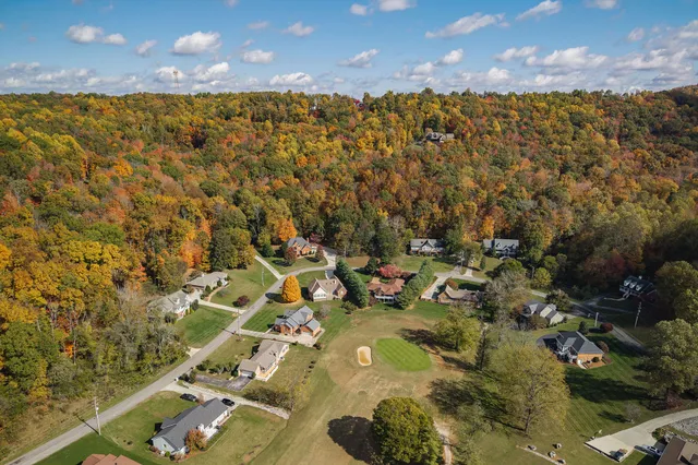 a front view of a house with a garden and trees