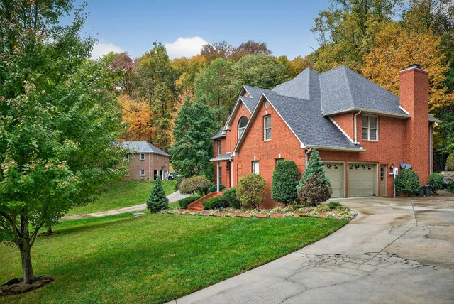 a front view of a house with a yard and trees