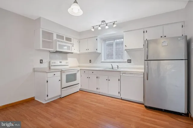 a kitchen with white cabinets and white appliances