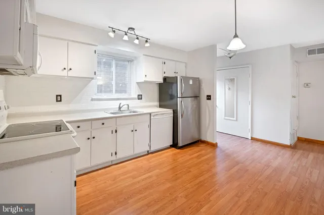 a kitchen with white cabinets and stainless steel appliances