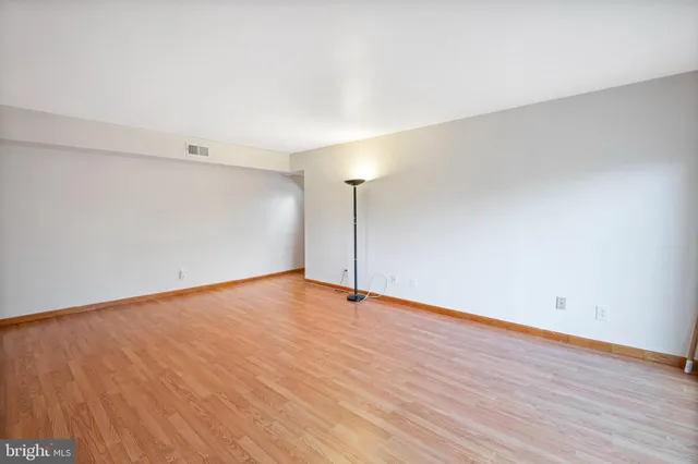 a view of an empty room with wooden floor