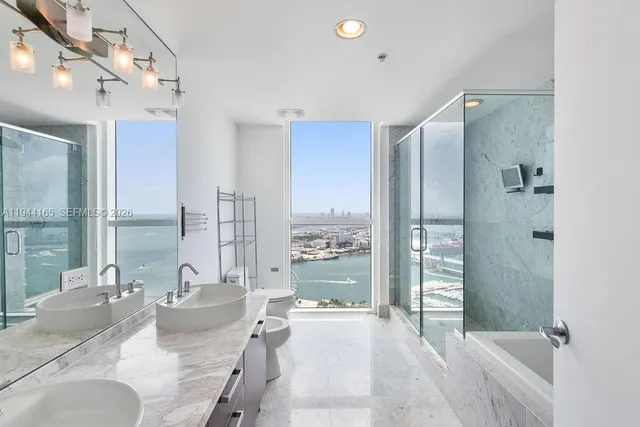 a bathroom with a sink a toilet and shower