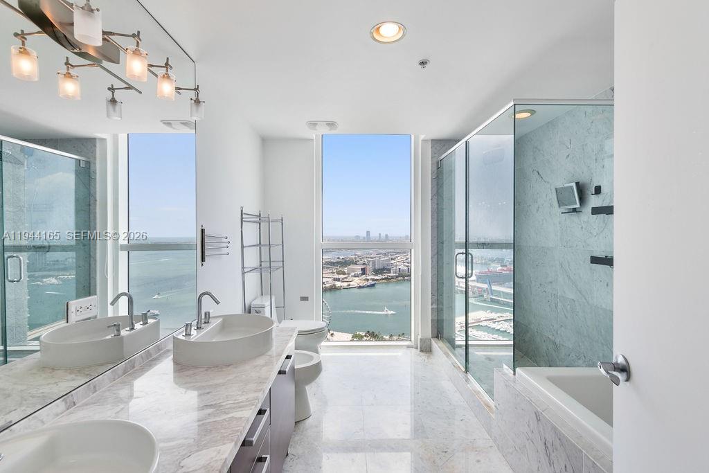 253 Northeast 2nd Street, Unit 4608 Miami, FL 33132 - Photo 25 of 37 a large bedroom with a large tub and shower