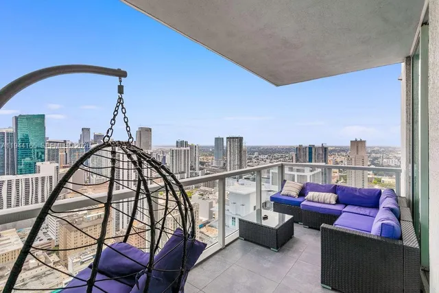 a view of roof deck with couches and city view