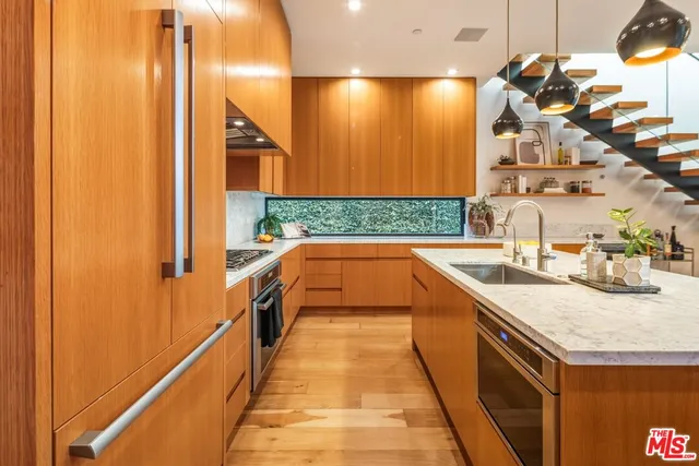 a kitchen with a sink a counter top space and living room area