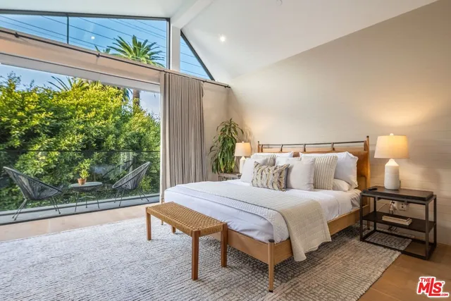 a bedroom with a large bed and a potted plant