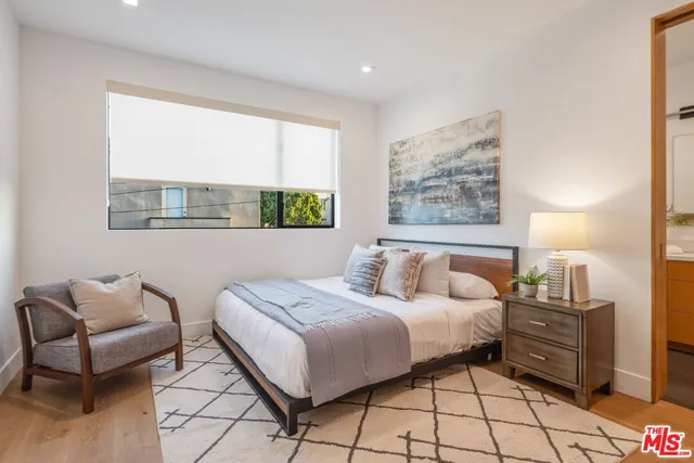 a large bedroom with a bed and wooden floor