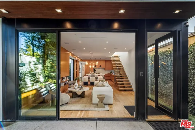 a living room with large windows and furniture