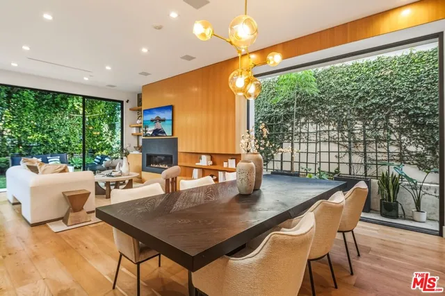 a kitchen with stainless steel appliances granite countertop a sink a refrigerator and chairs