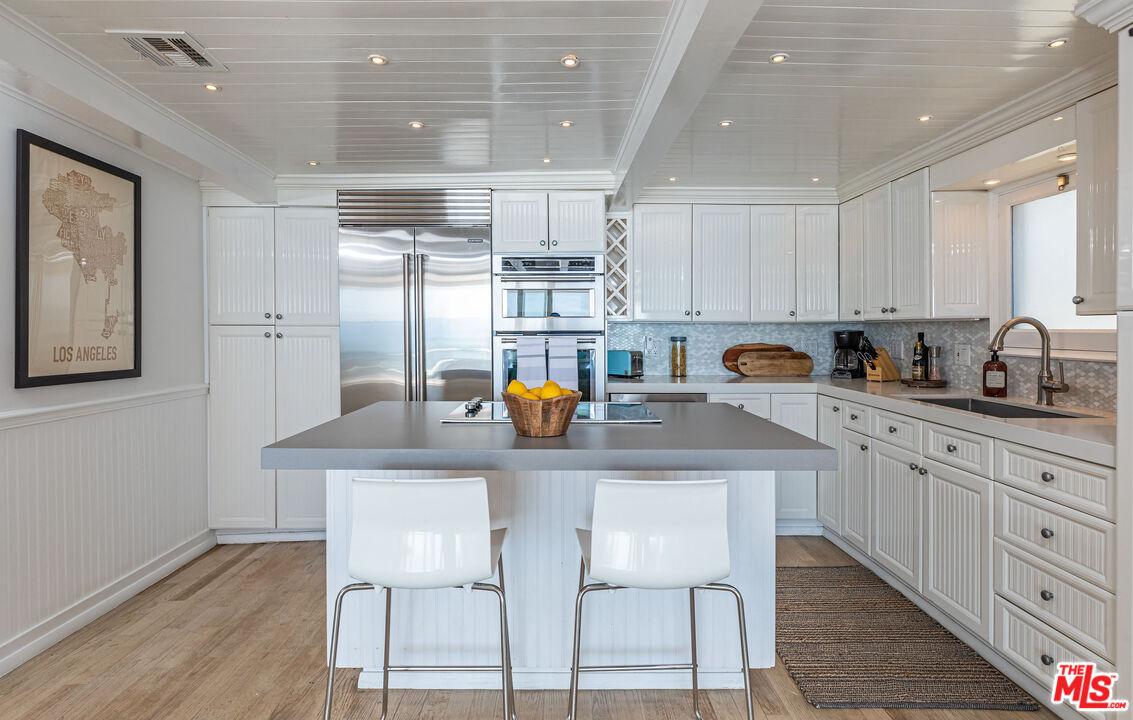 20828 Pacific Coast Highway Malibu, CA 90265 - Photo 6 of 23 a kitchen with stainless steel appliances granite countertop a table chairs refrigerator and sink