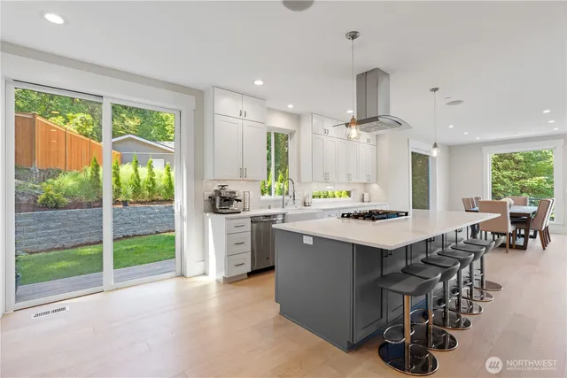 a kitchen with kitchen island a large counter top space a sink stainless steel appliances and cabinets