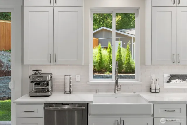 a kitchen with stainless steel appliances white cabinets and a window