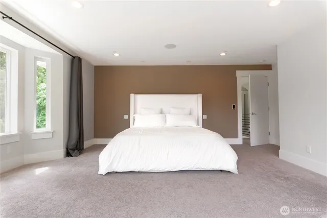 a bedroom with a bed and a large window