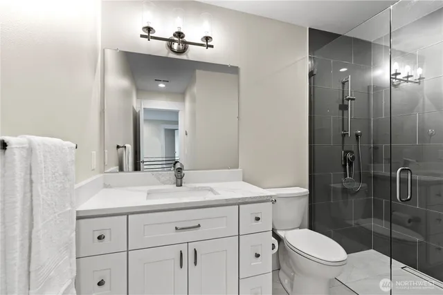 a bathroom with a sink a toilet and shower