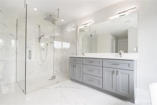 a bathroom with a shower sink and mirror