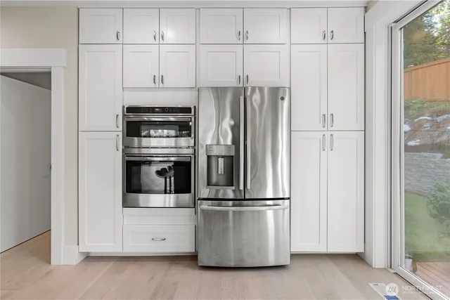 a kitchen with appliances a refrigerator and cabinets