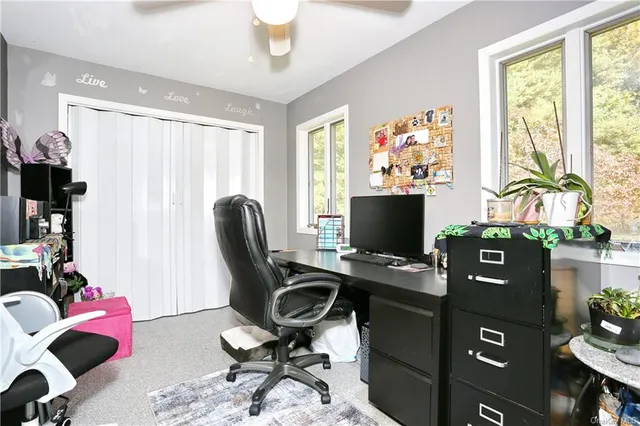 a view of a workspace with furniture and a window