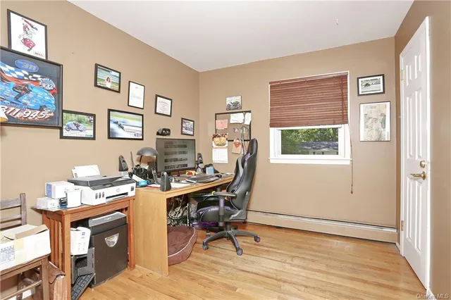 a view of a workspace with furniture and a window