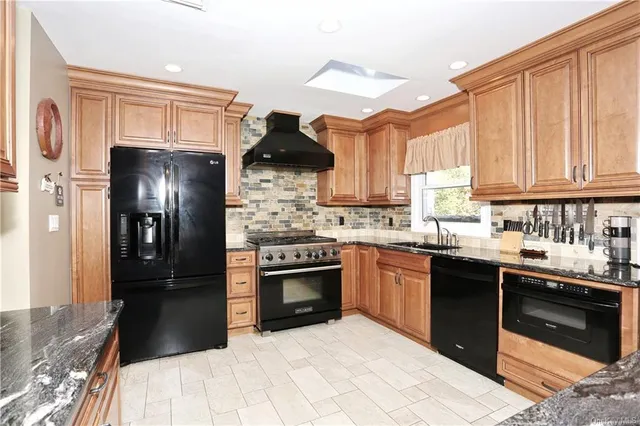 a kitchen with stainless steel appliances granite countertop a refrigerator and a sink