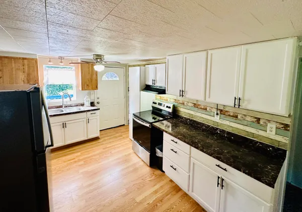 a kitchen with stainless steel appliances a stove and white cabinets