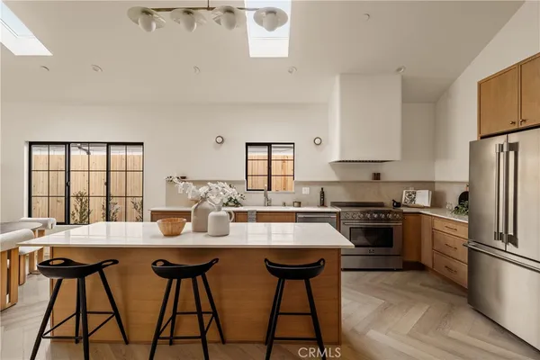 a kitchen with stainless steel appliances granite countertop a stove a sink dishwasher a stove a refrigerator with a dining table and chairs