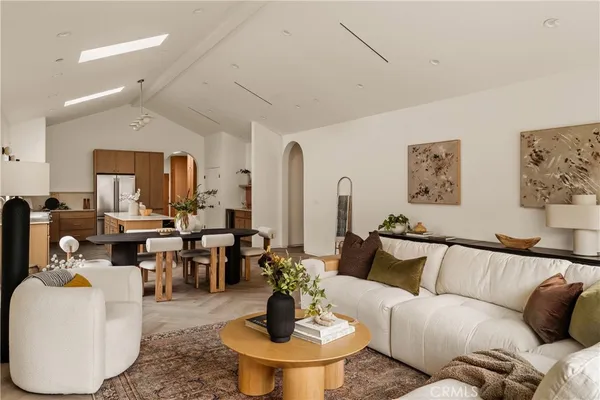 a living room with furniture and a dining table with kitchen view